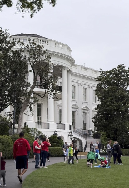 The White House lawn with guests walking on it.