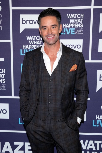 Jesse Lally standing in front of the WWHL step and repeat.