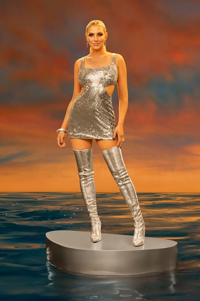 Gina Kirschenheiter wearing a silver dress in front of a sunset.