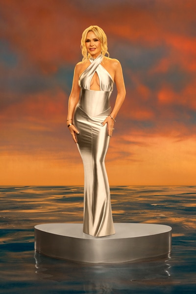 Full length of Tamra Judge wearing a silver dress in front of a sunset.