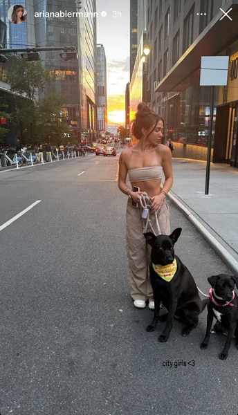 Ariana Biermann standing in the street with her dogs in New York City.