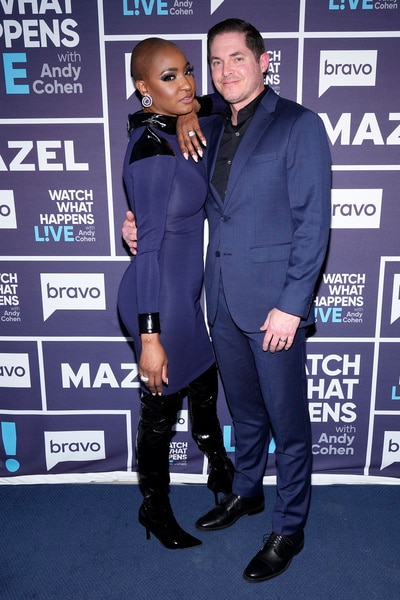 Guerdy Abraira and Russell Abraira posing next to each other in front of a step and repeat.