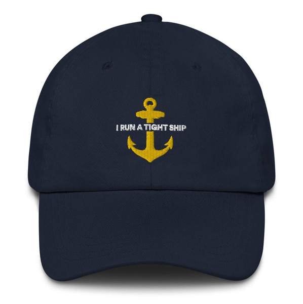 A baseball cap that reads "I run a tight ship"