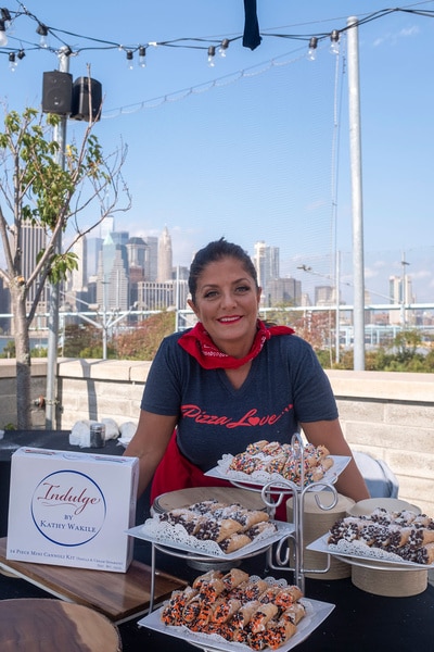 Kathy Wakile posing outdoors with desserts.