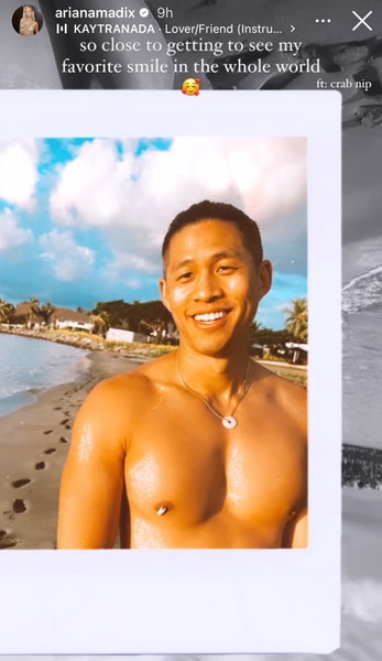 Daniel Wai standing outside with a beach, white clouds, and blue skies behind him