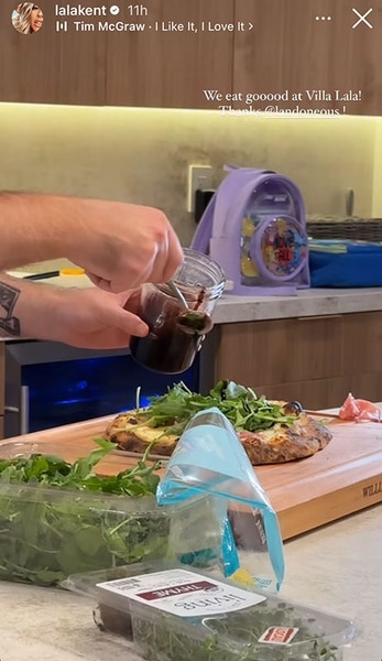 Toppings being added to Lala Kent's pizza in her kitchen.