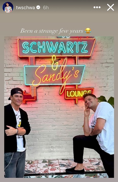 Tom Schwartz and Tom Sandoval posing together in front of the Schwartz & Sandy's lounge sign.