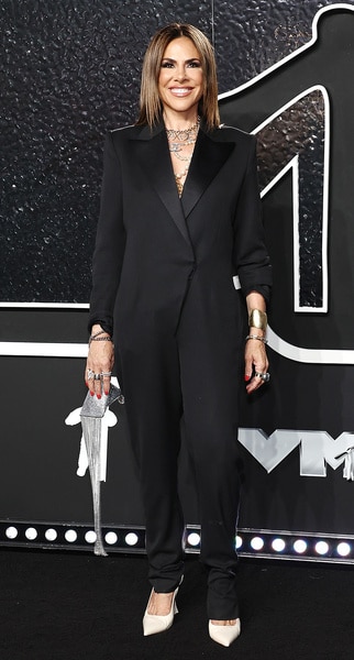 Jenn Fessler wears a black blazer and black pants and smiles on the carpet at the video music awards