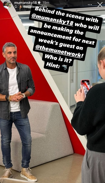 Mauricio Umansky getting filmed in front of a red wall and a couch