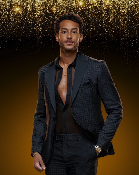 Michols Pena wears a suit in front of a backdrop in Southern Hospitality Season 3.