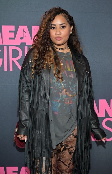 Tammy Rivera posing in front of a step and repeat.