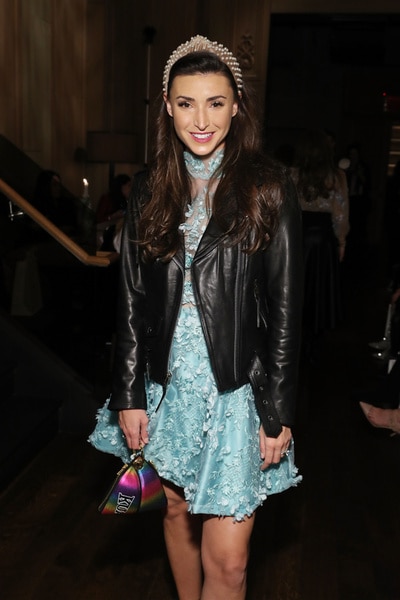 Bronwyn Newport wearing a blue dress, leather jacket and a headband