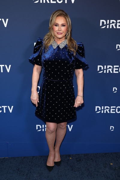 Kathy Hilton posing in front of a step and repeat.