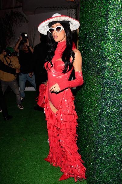 Full legnth of Paris Hilton wearing a red outfit and a black wig