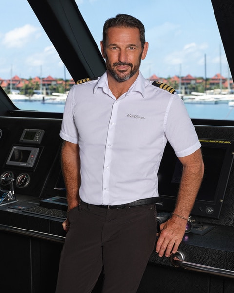 Captain Jason Chambers wearing his captain uniform standing in the ship command center