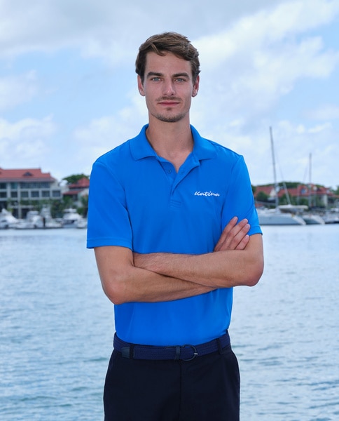 Harry Van Vliet wearing a blue polo in front of a marina.