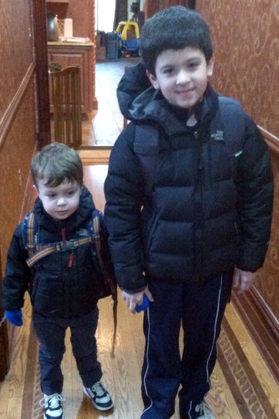 Jacqueline Laurita's sons CJ and Nicholas holding hands in a narrow hallway