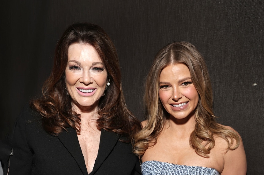 Lisa Vanderpump and Ariana Madix smiling in front of a step and repeat.