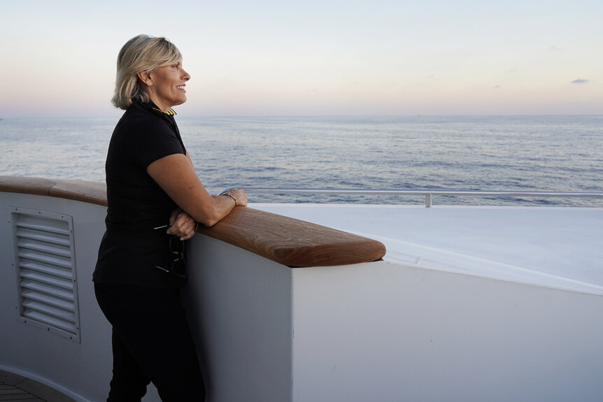 Captain Sandy Yawn smiling out at a sunset while aboard the Mustique yacht.