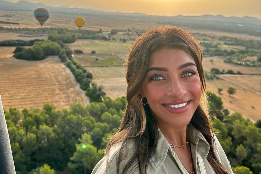 Gia Giudice smiling in front of a hot air balloon in Spain.