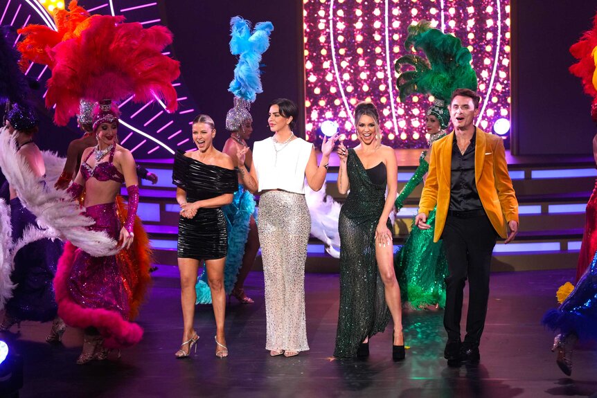 Ariana Madix, Katie Maloney, Scheana Shay, and James Kennedy standing next to each other on stage with dancers during The Bravos at BravoCon 2023.