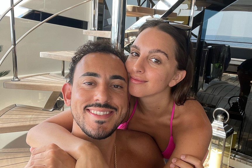 Alexia Umansky and Jake Zingerman embrace each other on a yacht.