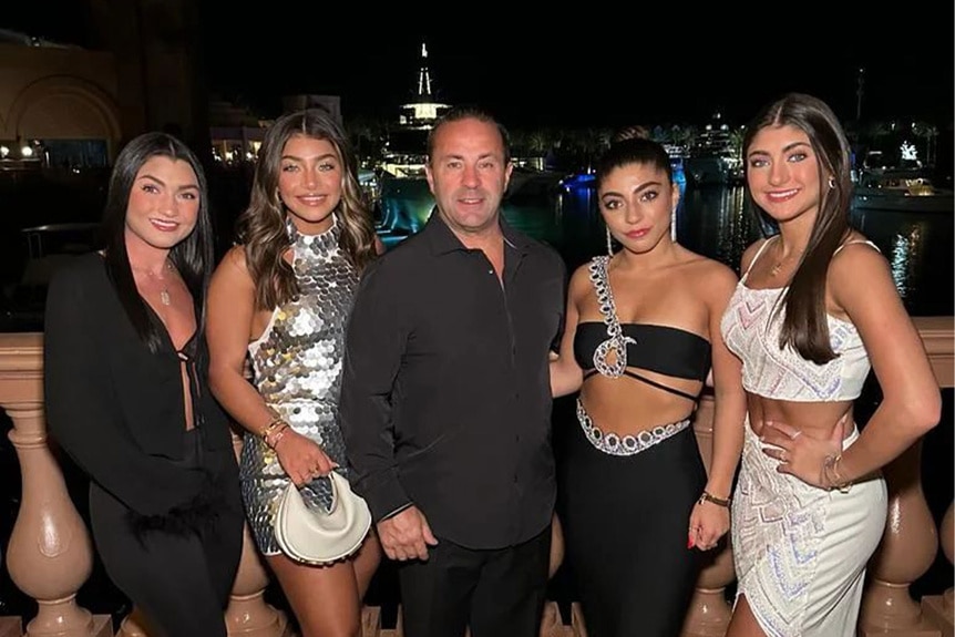 Joe Giudice smiling with his daughters.