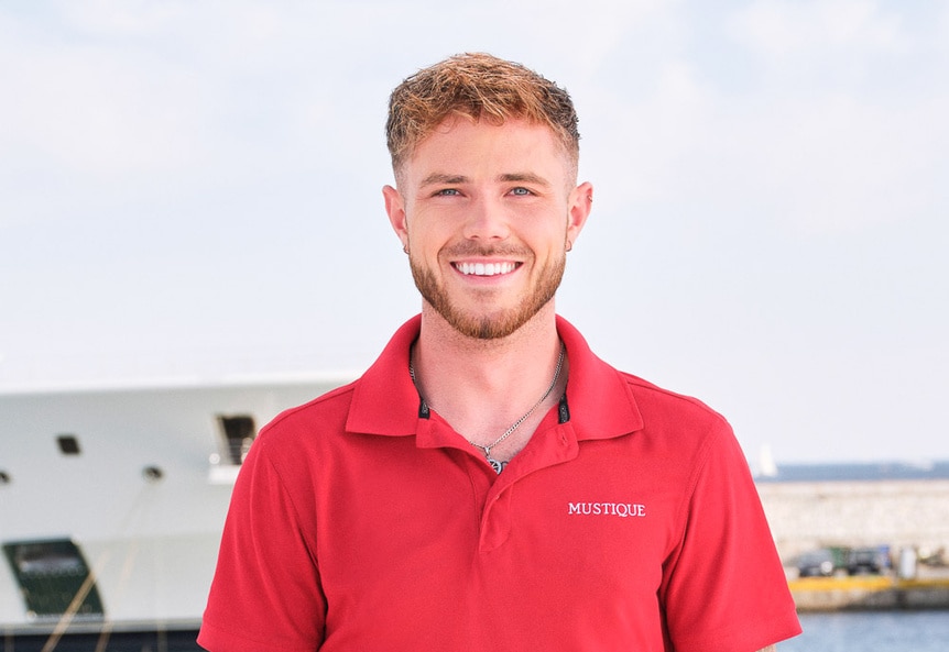 Nathan Gallagher wearing a red polo in front of a waterfront