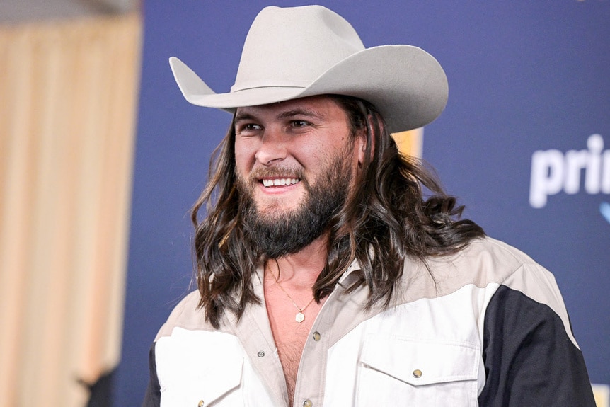 Brock Davies wears a cowboy hat arrives for the 57th Academy of Country Music awards