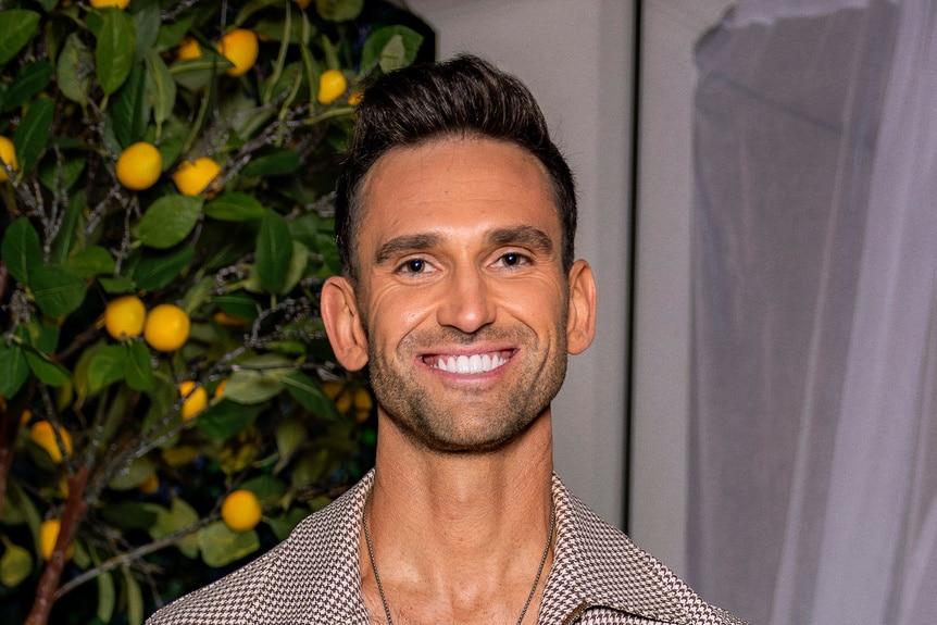 Carl Radke smiling in front of a themed set.