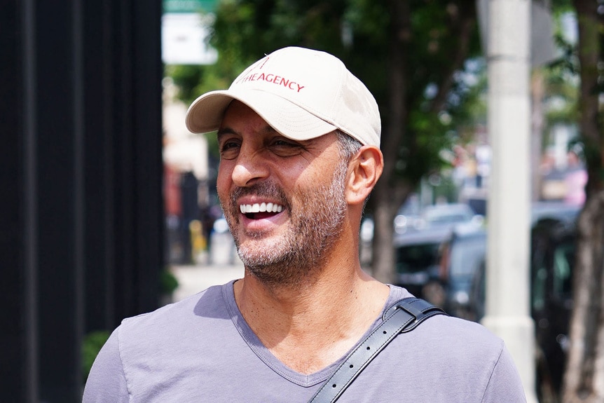 Mauricio Umansky smiling while walking down the street.