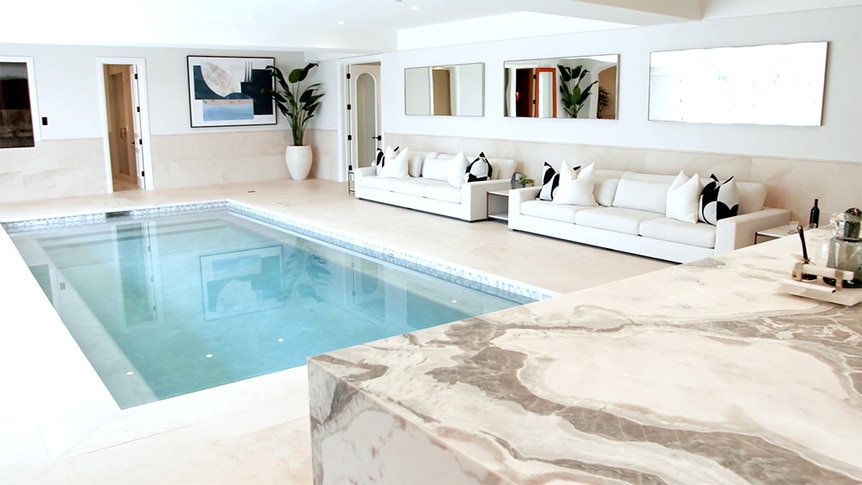 An indoor pool in Josh Altman's listing featuring seating and a bar.