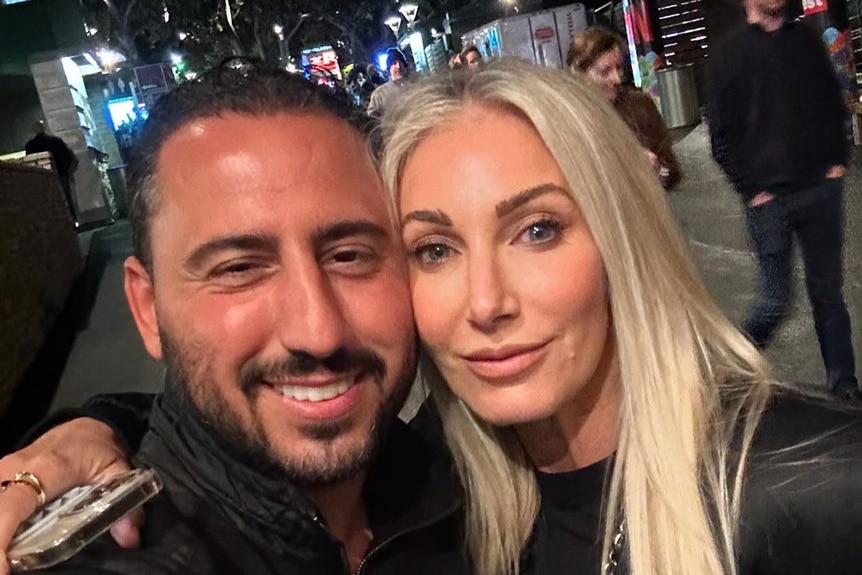 Josh Altman and Heather Altman posing together on a sidewalk.