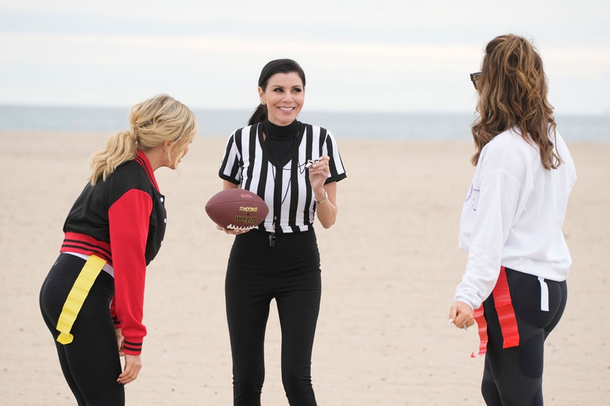 Heather Dubrow, Tamra Judge, and Emily Simpson playing flag football on a beach