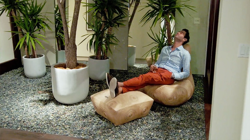 Josh Flagg sitting with a drink in a courtyard.