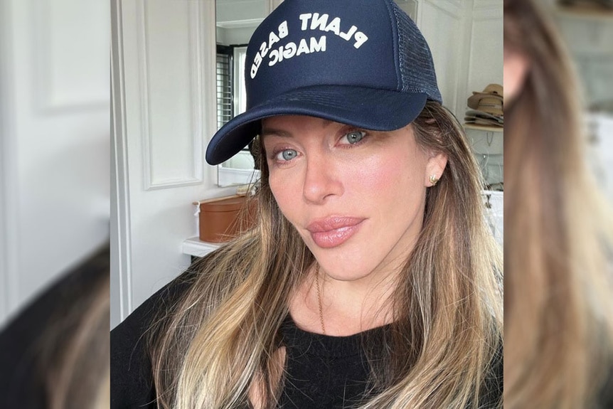 Dina Manzo wearing a black top and a trucker hat