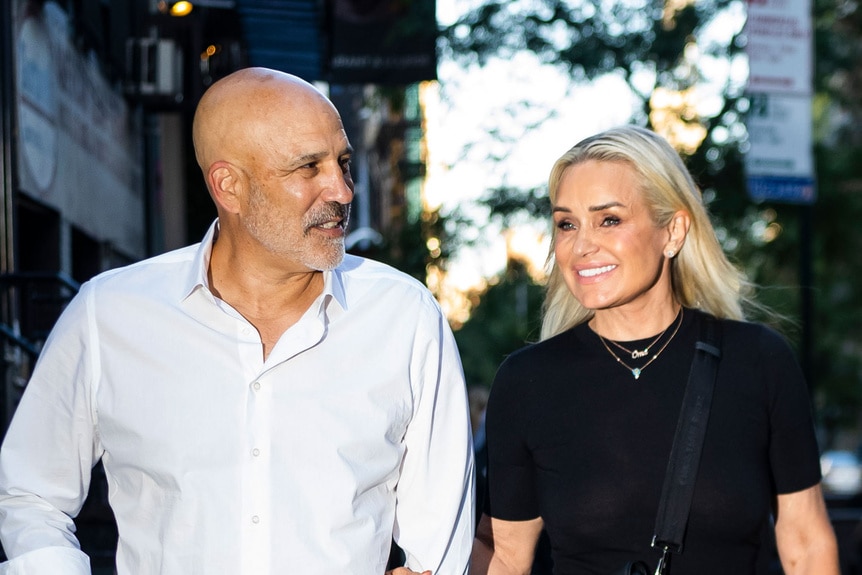 Yolanda Hadid and Joseph Jingoli holding hands and walking down a street.