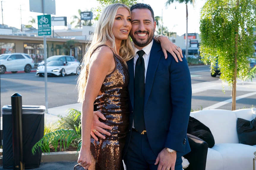 Josh Altman and Heather Altman hugging in front of their new office.