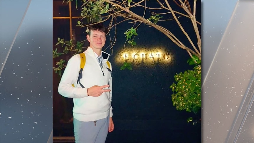 Jack Barlow posing in front of a wall with a sign.