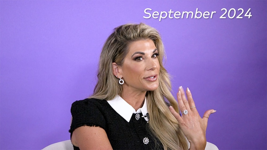 Alexis Bellino talking and showing her engagement ring in front of a purple background.