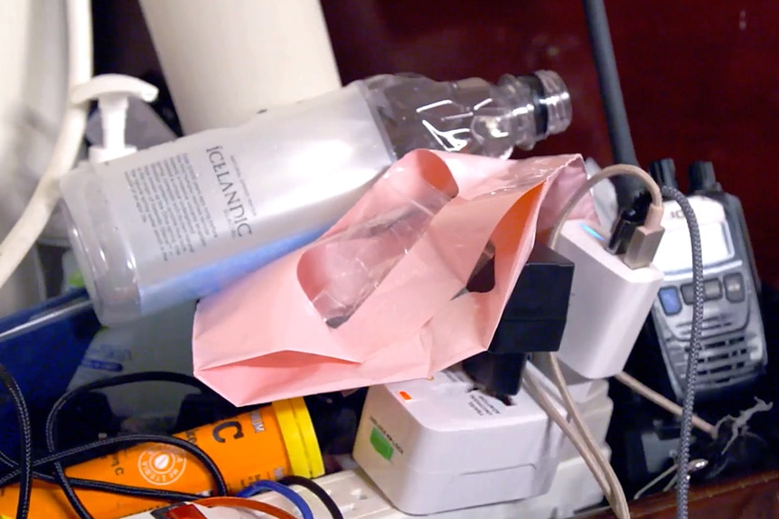 Joe Bradley's nightstand with electrical outlets and open water bottles.