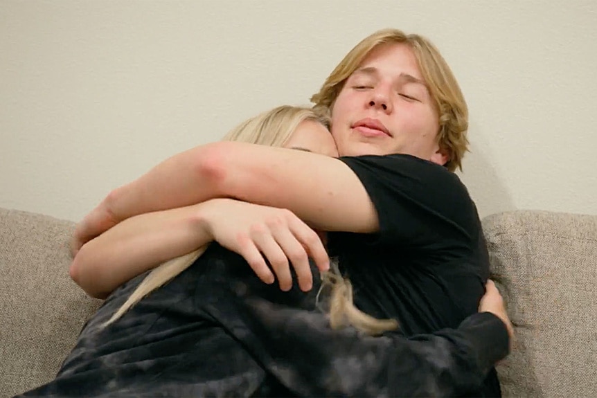 Jennifer Pedranti and Dawson Pedranti hugging on a sofa.