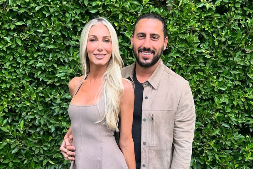 Heather Altman and Josh Altman together in front of a shrub outside