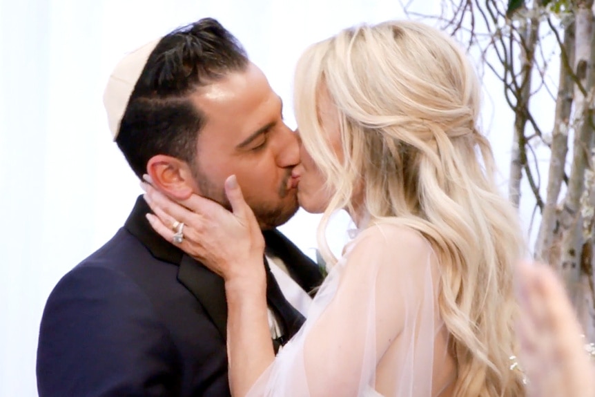 Josh Altman and Heather Altman kissing on their wedding day.