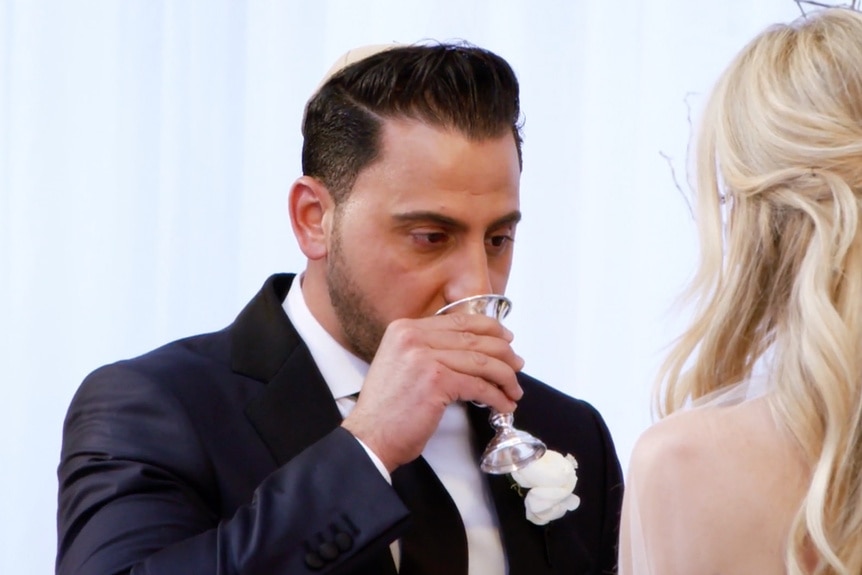 Josh Altman drinking wine during his wedding ceremony.