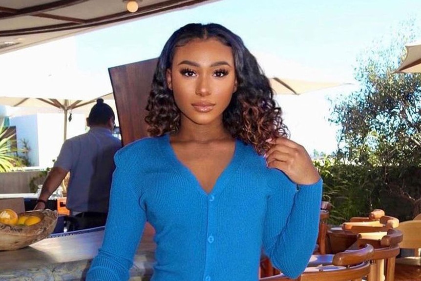 Noelle Robinson wearing a long sleeve blue dress at a restaurant.