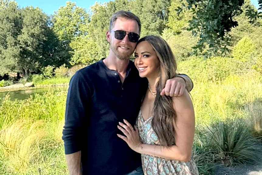 Kirsten Doute with her boyfriend, Luke Broderick, standing in a field.