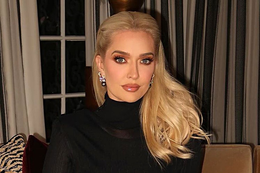 Erika Jayne wearing a black dress in her living room.