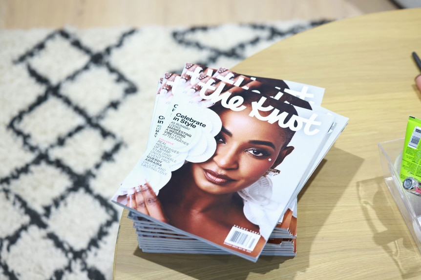 Stacks of The Knot magazine with Guerdy Abraira on the cover.