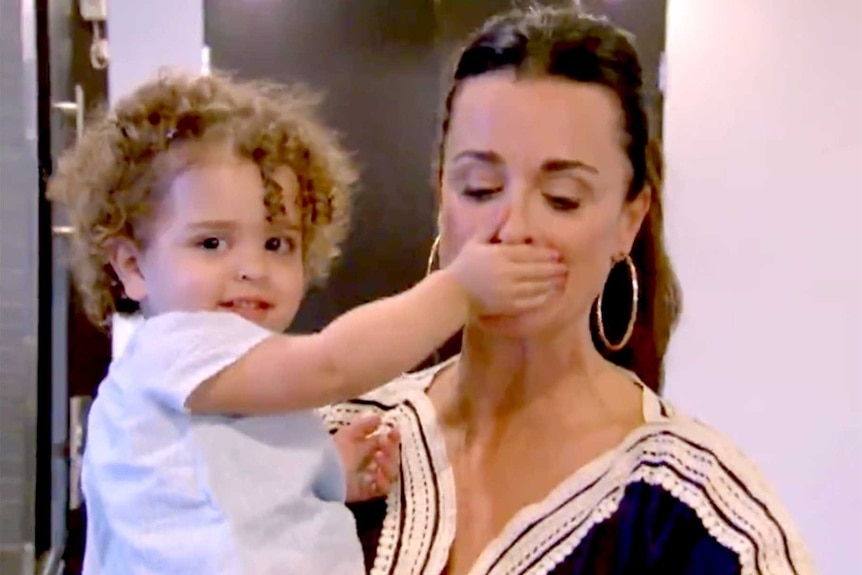 Kyle Richards holding her daughter Portia while she covers her mouth in the premiere episode of RHOBH